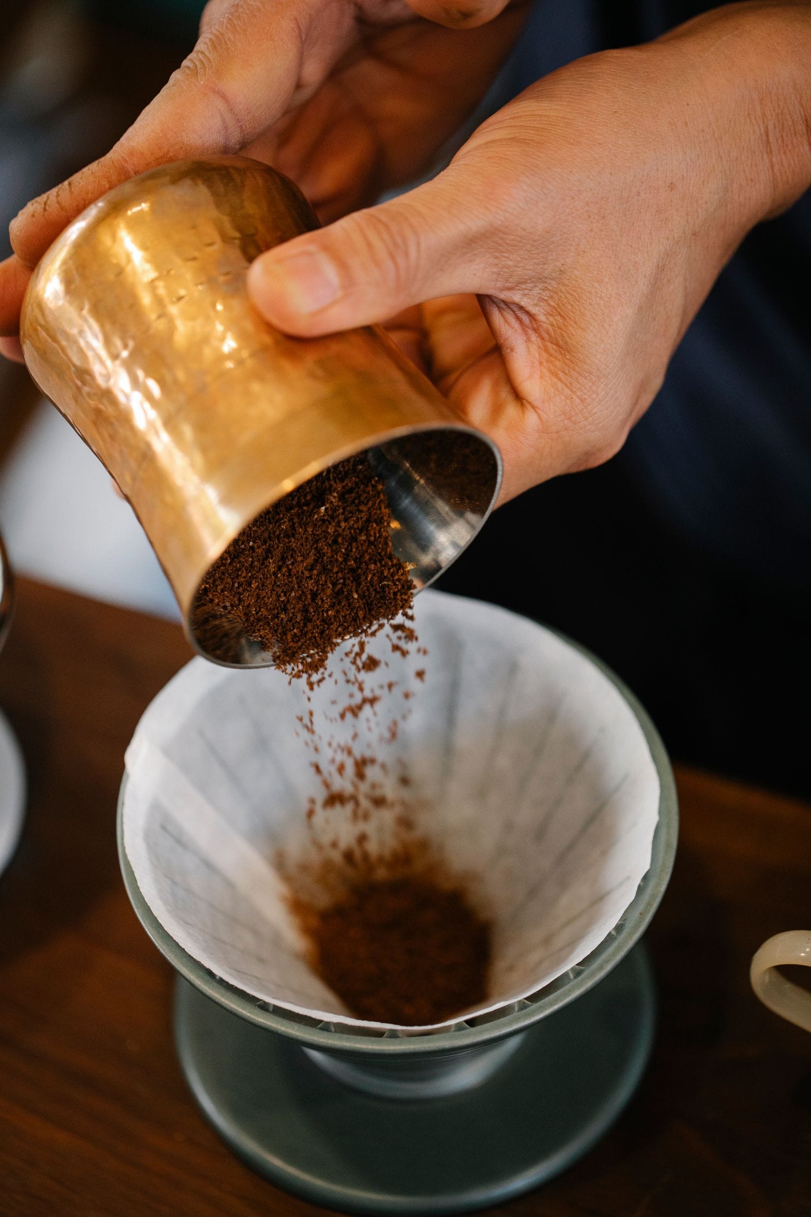 Barista preparando un café de filtro pour-over con tetera de cuello de cisne