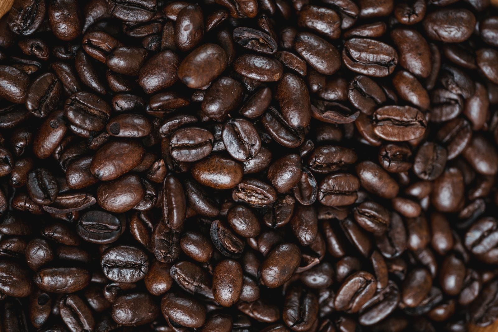 Granos de café recién tostados en textura de cerca, listos para moler