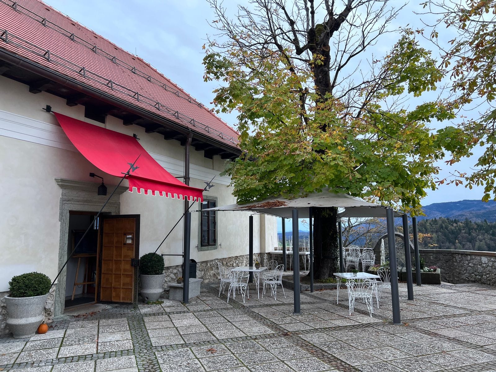Terraza de Cafè Aurora con mesas de mármol bajo los toldos al sol de la mañana