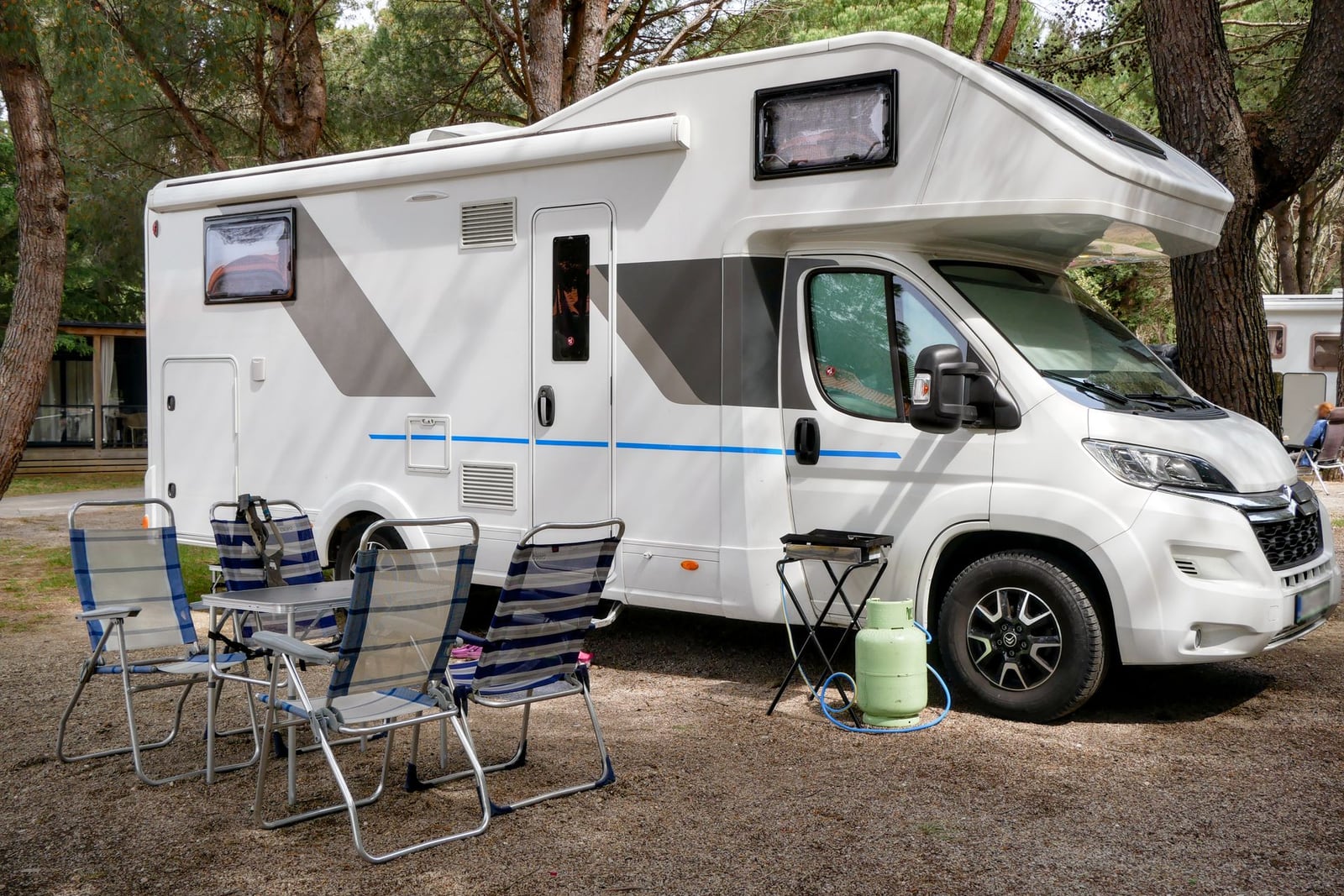 Parcela con autocaravana entre pinos en el camping