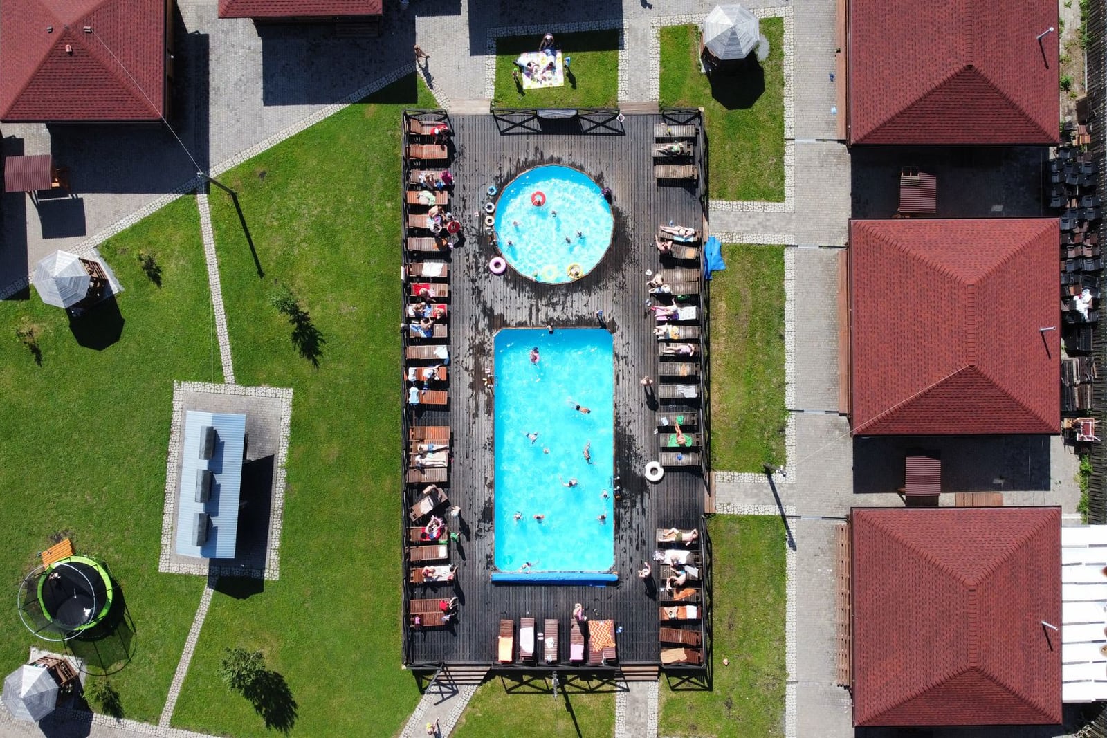 Piscina del camping rodeada de tumbonas y pinos
