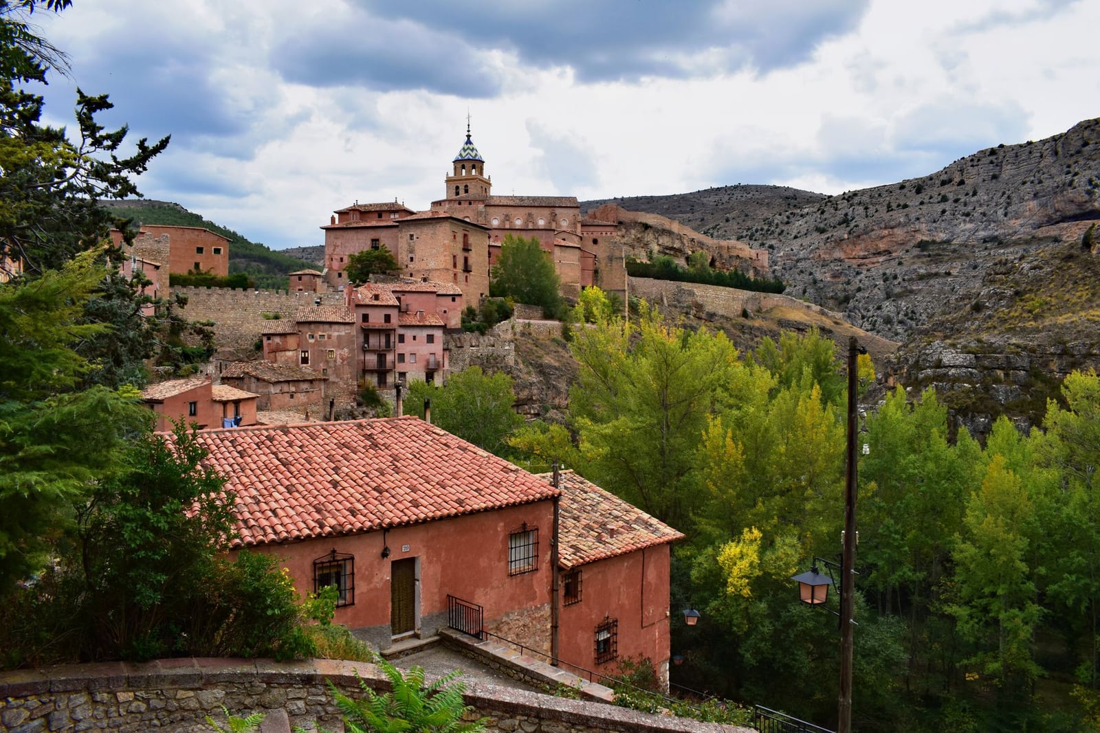 Fachada exterior de la masía de piedra de Mas de les Espigues con ventanas de madera