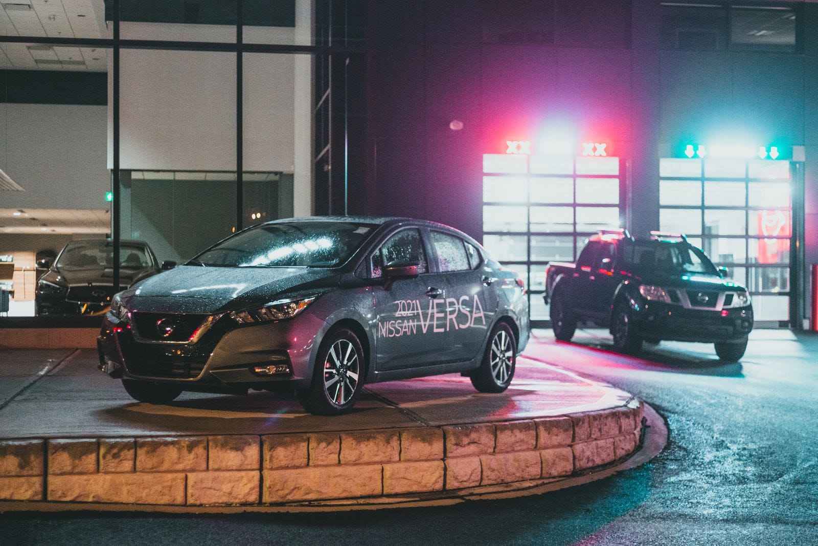 Showroom de AutoMare iluminado con luz de neón, con varios coches premium expuestos