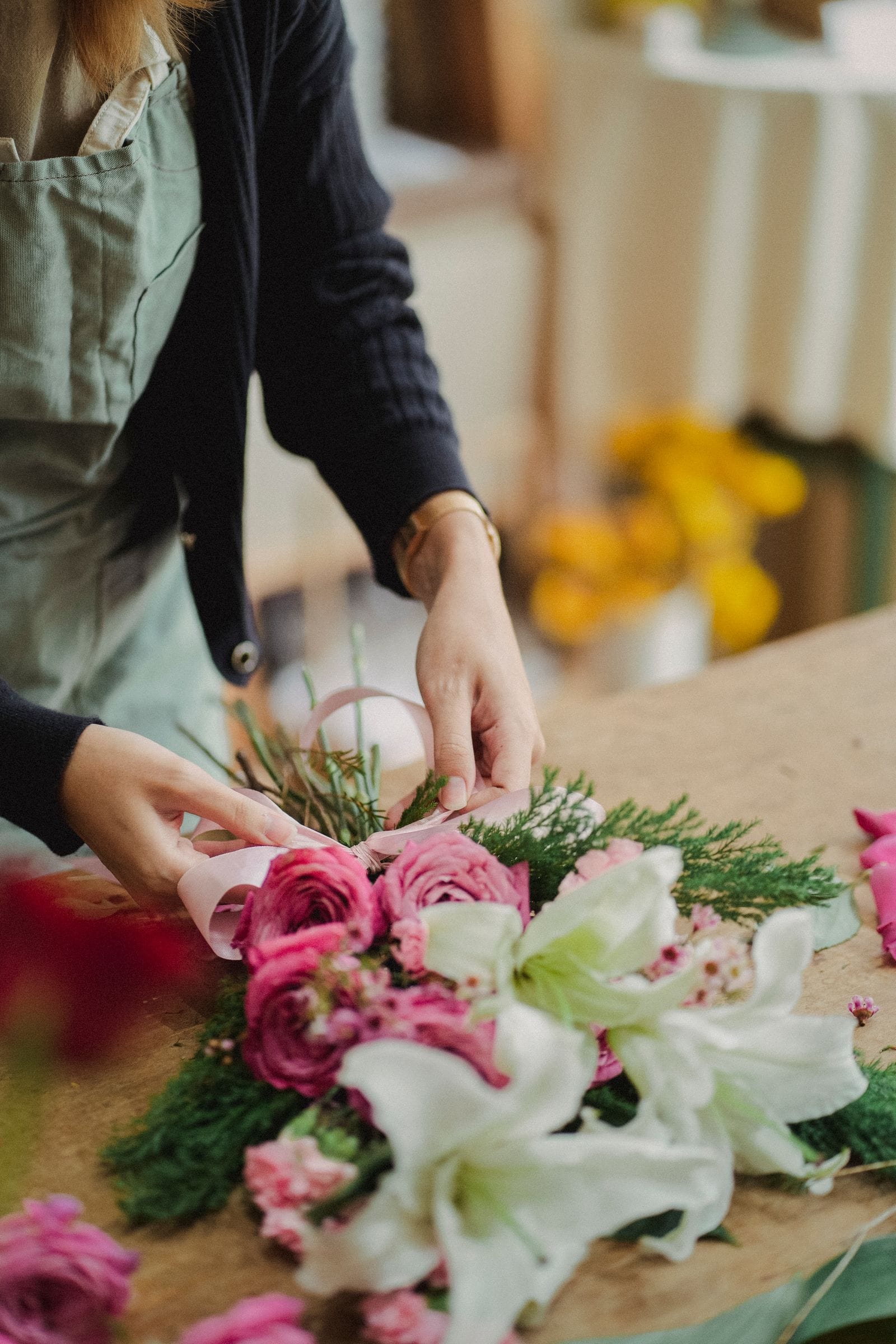 Manos de florista atando un ramo con cinta de raso