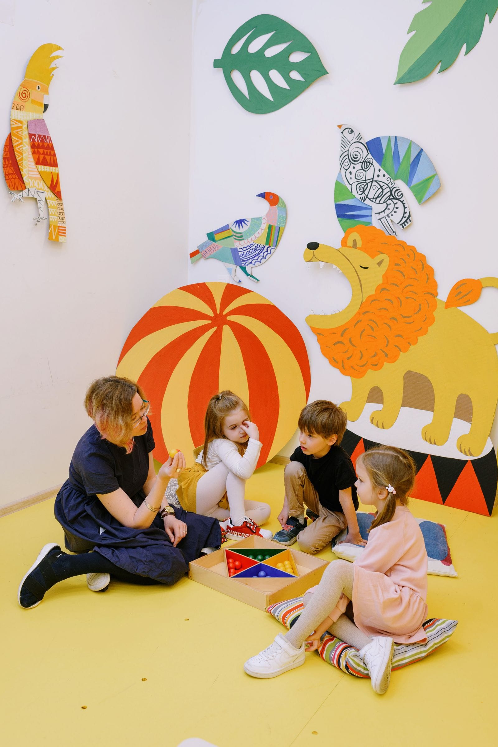 Una educadora acompaña a un grupo de niños y niñas durante una actividad en el aula de la escuela infantil