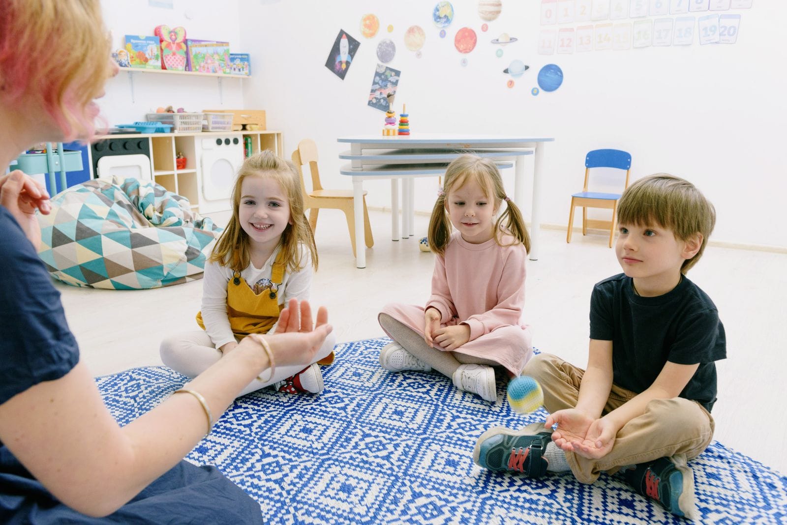 Dos niños concentrados en una actividad de manipulación sobre la mesa del aula