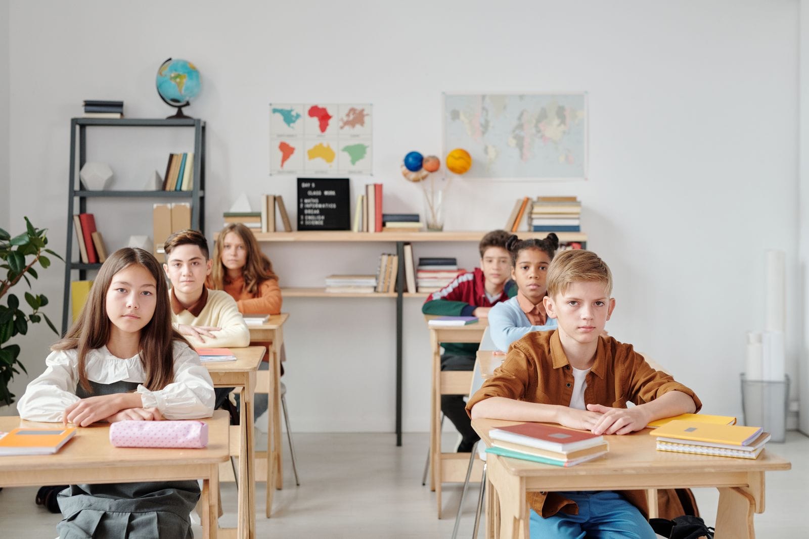 Rincón del aula con estanterías bajas de madera llenas de cuentos y libros al alcance de los niños