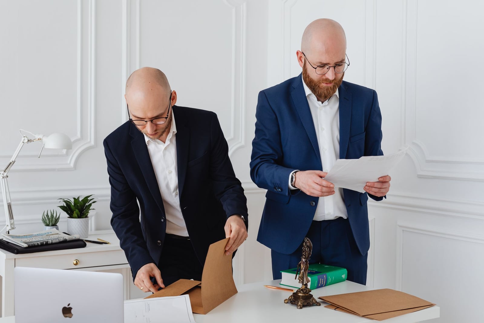 Dos asesores de Terramar, hombres de negocios, revisando una póliza sentados a una mesa de la oficina