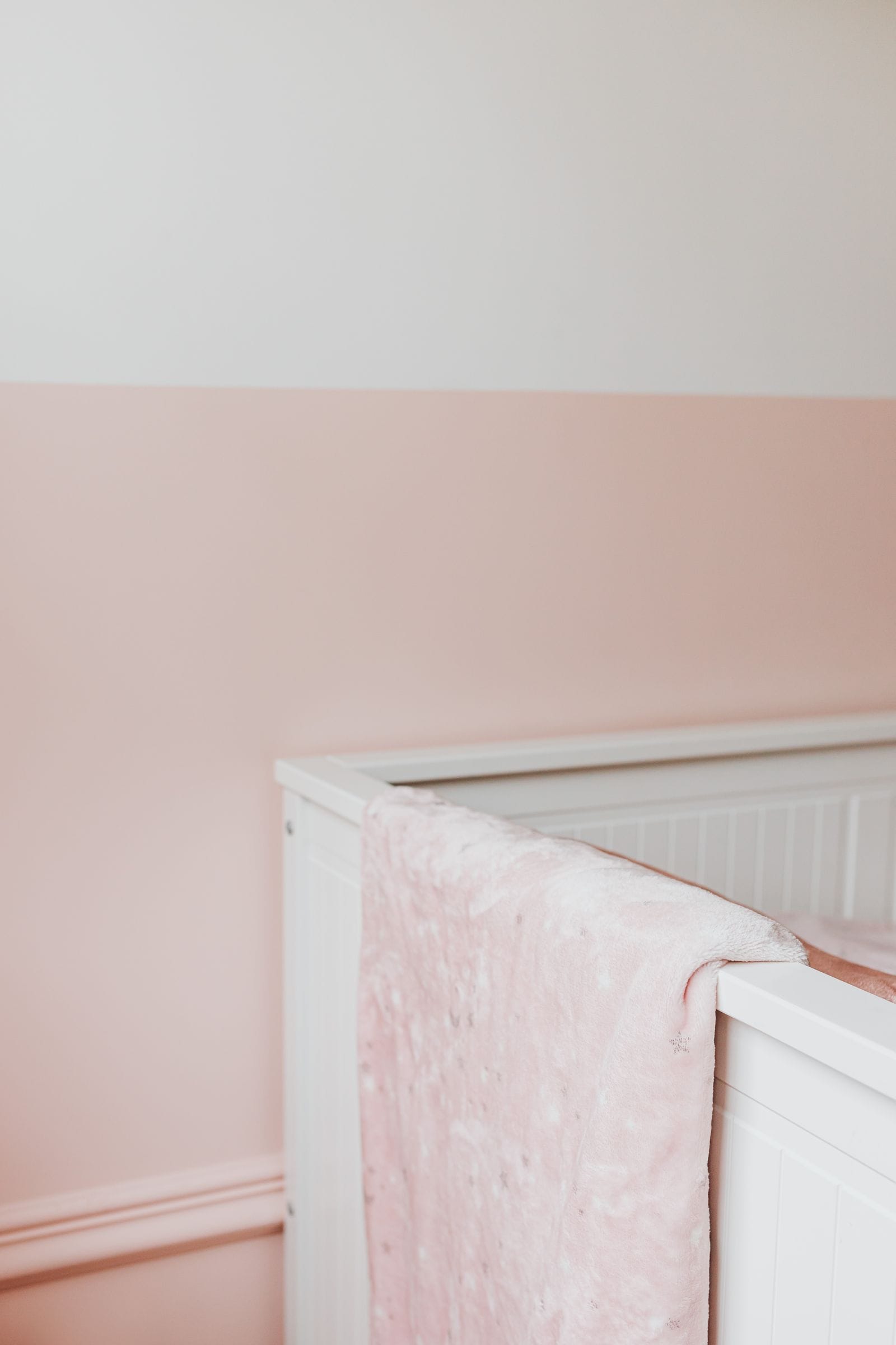 Cuna de madera vestida con ropa de cama suave en una habitación infantil